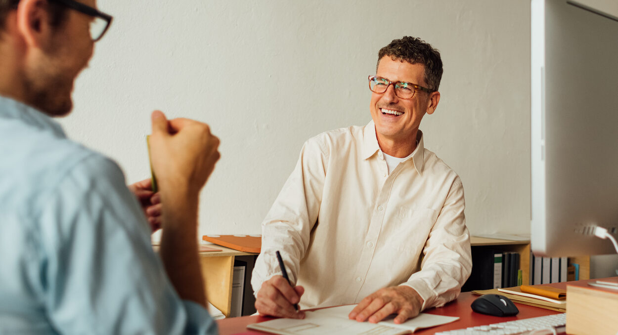 two people talking in front of computer